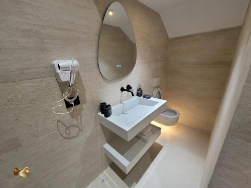ein Badezimmer mit einem weißen Waschbecken und einem Spiegel in der Unterkunft Infinity Villa in Rrushkull