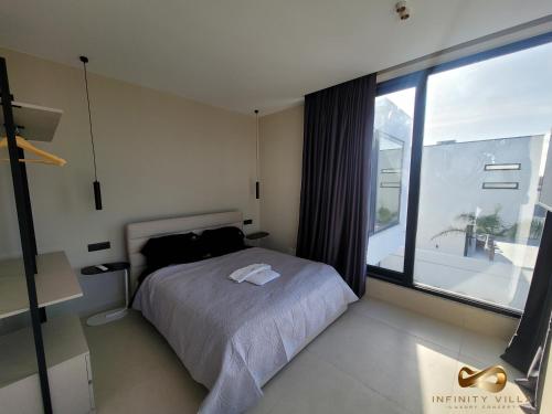a bedroom with a bed and a large window at Infinity Villa in Rrushkull