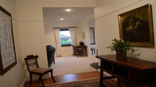 a living room with a table and a painting on the wall at Coolamon on Marsh in Armidale