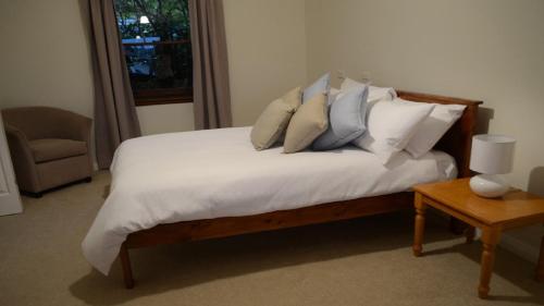 a bedroom with a bed with white sheets and pillows at Coolamon on Marsh in Armidale