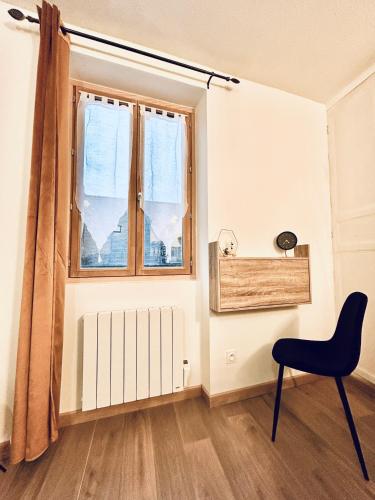 a chair and a window in a room at Au 15 Bis - Studio Hyper Centre in Saint-Amand-Montrond