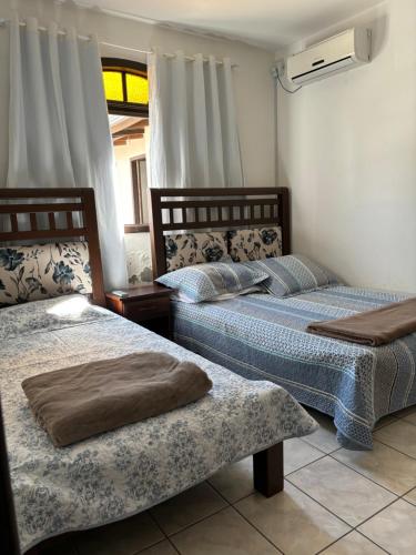 two beds sitting next to each other in a room at Casas Verão Bombinhas in Bombinhas