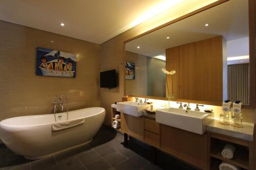 a bathroom with two sinks and a large mirror at Ossotel Legian in Legian