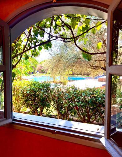 an open window with a view of a garden at Le Domaine de Carole Marrakech in Akkara