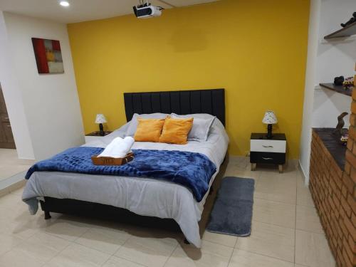 a bedroom with a large bed with two orange pillows at Samor centro histórico Bogota in Bogotá