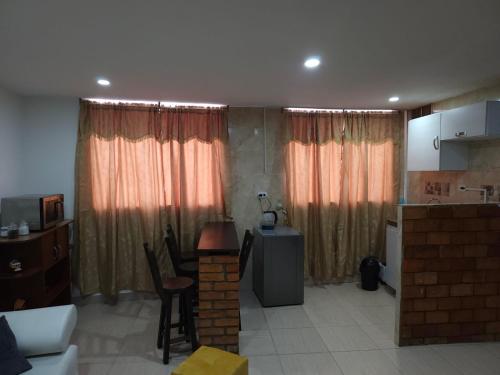 a kitchen and a living room with curtains and a table at Samor centro histórico Bogota in Bogotá