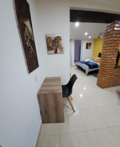 a living room with a desk and a bedroom at Samor centro histórico Bogota in Bogotá