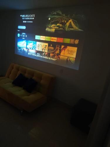 a flat screen tv hanging on a wall above a couch at Samor centro histórico Bogota in Bogotá