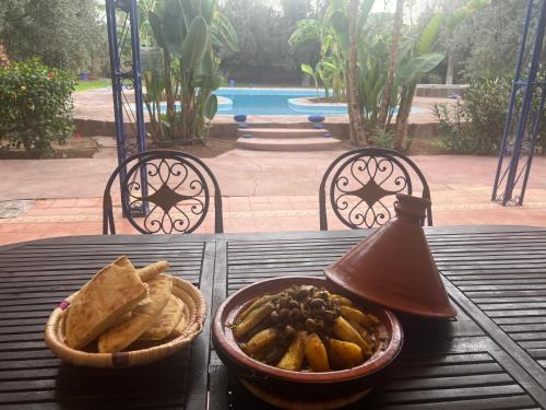 a table with a bowl of chips and a bowl of bread at Le Domaine de Carole Marrakech in Akkara