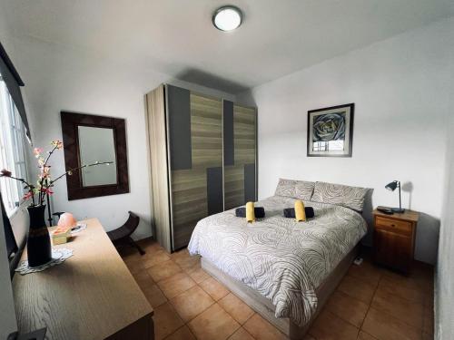 a bedroom with a bed and a dresser and a table at Sta Cruz centro con balcón, WiFi super rápida y zona para trabajar en remoto, cerca intercambiador in Santa Cruz de Tenerife