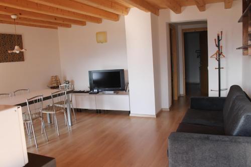 a living room with a couch and a table with a television at B&B Val Maschi in Lamon