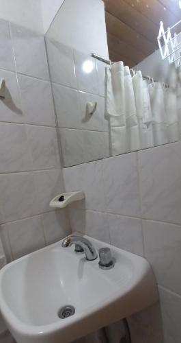 a white bathroom with a sink and towels at Departamento Anita in El Hoyo