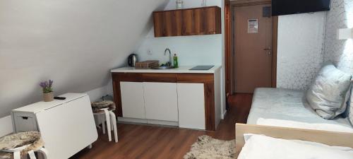 a small kitchen with a sink and a bed in a room at Snow White apartments in Kopaonik