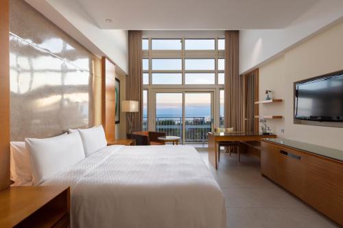 pokój hotelowy z dużym łóżkiem i dużym oknem w obiekcie Four Points by Sheraton Shenzhou Peninsula Resort w mieście Wanning