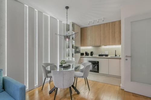 a kitchen and dining room with a table and chairs at Melody Apartment in Novi Beograd