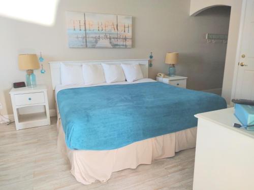 a bedroom with a large bed with a blue blanket at Pacific Plaza Resort in Oceano