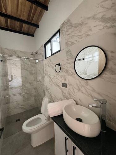 een badkamer met een toilet, een wastafel en een spiegel bij Hermoso apartamento en Pamplona in Pamplona
