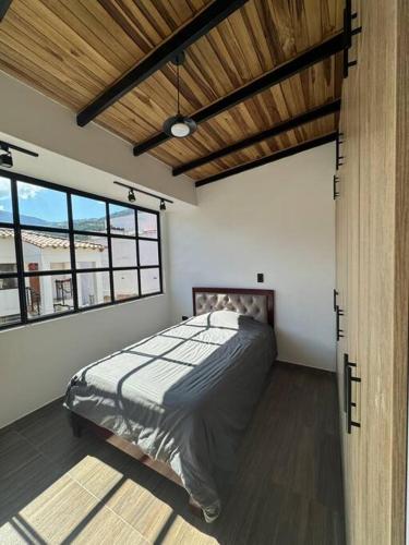 ein Schlafzimmer mit einem Bett in einem Zimmer mit Fenstern in der Unterkunft Hermoso apartamento en Pamplona in Pamplona