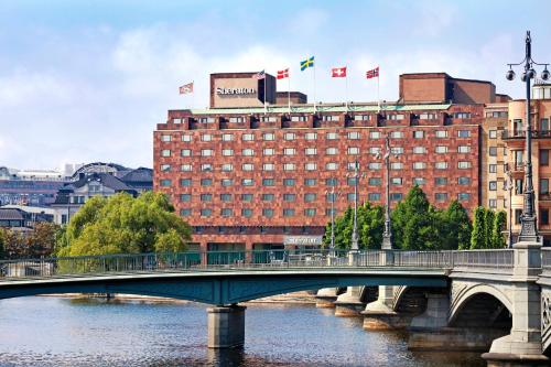 a bridge over a river with a building and flags at Sheraton Stockholm Hotel in Stockholm