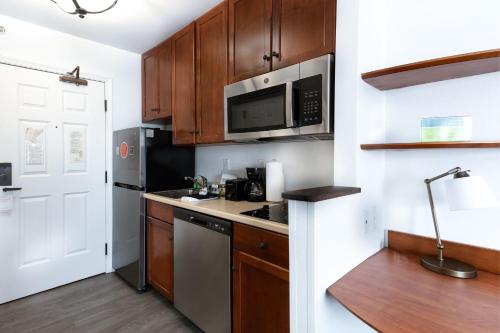a kitchen with wooden cabinets and stainless steel appliances at TownePlace Suites Fredericksburg in Fredericksburg