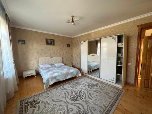 1 dormitorio con cama y espejo en Gabala villa Exceptional, en Gabala