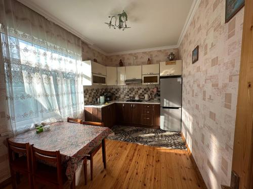 a kitchen with a table and a refrigerator at Gabala villa Exceptional in Gabala