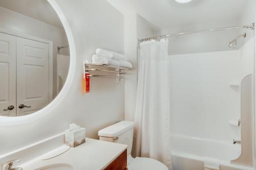 a white bathroom with a toilet and a mirror at TownePlace Suites Fredericksburg in Fredericksburg