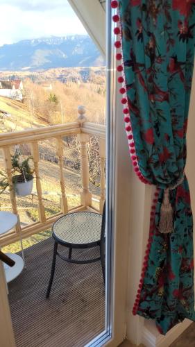 a room with a balcony with a chair and a window at Carpathia Magic -adults only in Peştera