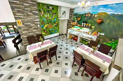 a restaurant with tables and chairs in a room at Hotel Machupicchu Adventure in Machu Picchu