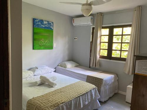 a room with two beds and a picture of a bike on the wall at Apartamentos Aconchegantes, Villa da Praia in Praia do Forte