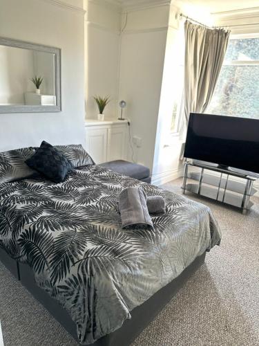 a bedroom with a bed and a flat screen tv at Tiye cosy stays in Stoke on Trent