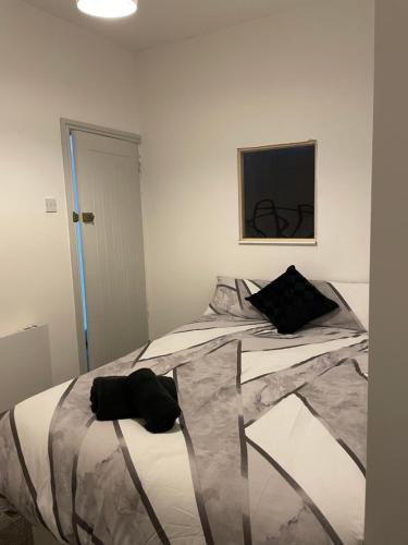 Un dormitorio con una cama con una almohada negra. en Tiye cosy stays, en Stoke on Trent