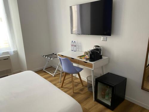 a small room with a desk with a microwave and a bed at Belltower Elegans Guest House in Rome