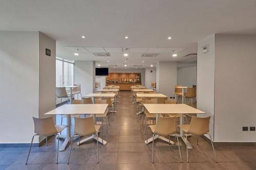 a row of tables and chairs in a room at City Express by Marriott Tampico Altamira in Tampico