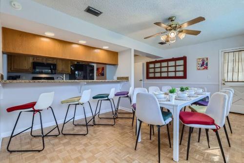 a dining room with a white table and chairs at Spacious Tampa Haven - Games - Pool - 7-15 min From ALL in Tampa