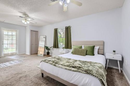 a bedroom with a large white bed with green pillows at Spacious Tampa Haven - Games - Pool - 7-15 min From ALL in Tampa