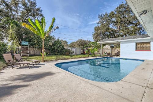 a swimming pool with two chairs and a house at Spacious Tampa Haven - Games - Pool - 7-15 min From ALL in Tampa