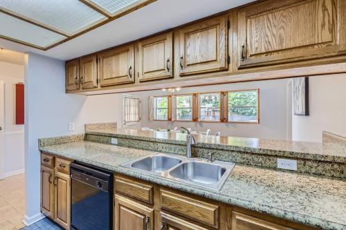 a kitchen with a sink and wooden cabinets at Spacious Tampa Haven - Games - Pool - 7-15 min From ALL in Tampa