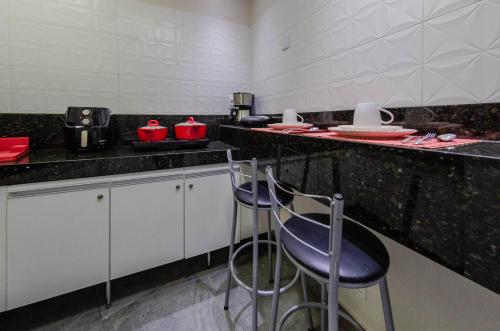 una cocina con ollas rojas y sartenes en una encimera en STUDIOS CORACAO EUCARISTICO en Belo Horizonte