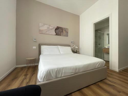 a bedroom with a large white bed and wooden floors at Belltower Elegans in Rome