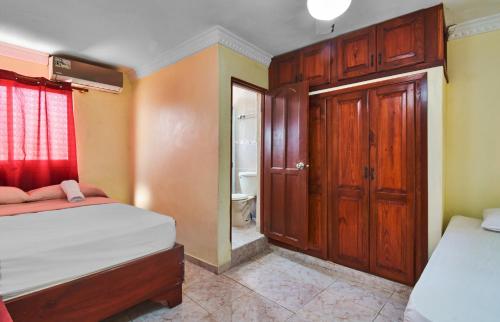 a small bedroom with two beds and a bathroom at BNB Tropical Island Aparthotel - Corales del Sur, Santo Domingo Este in Santo Domingo