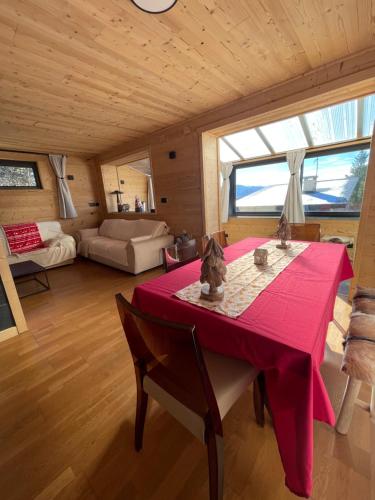ein Esszimmer mit einem roten Tisch in einem Zimmer in der Unterkunft Chalet Isard Pyrénées 2000 - 300m des pistes in Bolquere
