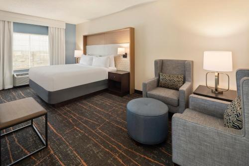 a hotel room with a bed and a chair at Holiday Inn Hotel & Suites Maple Grove Northwest Minneapolis-Arbor Lakes by IHG in Maple Grove