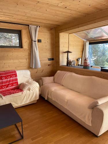 een woonkamer met een bank en een raam bij Chalet Isard Pyrénées 2000 - 300m des pistes in Bolquere Pyrenees 2000
