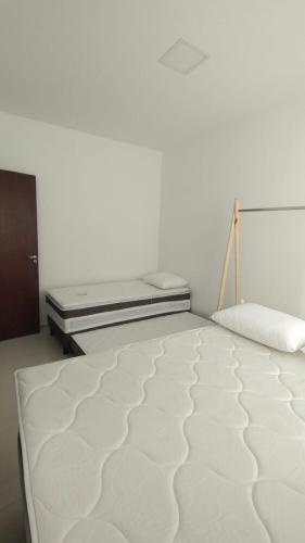 a white bedroom with a bed in a room at Guaibim in Guaibim