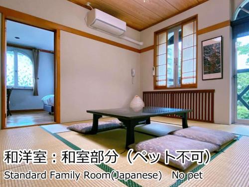 un soggiorno con tavolo e divano di Lodge Atelier a Hokuto