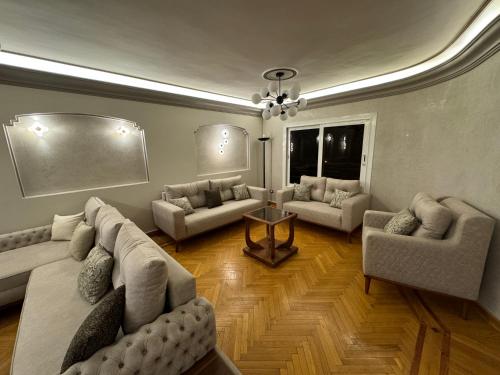 uma grande sala de estar com sofás e uma mesa em Elegant Apartment no Cairo
