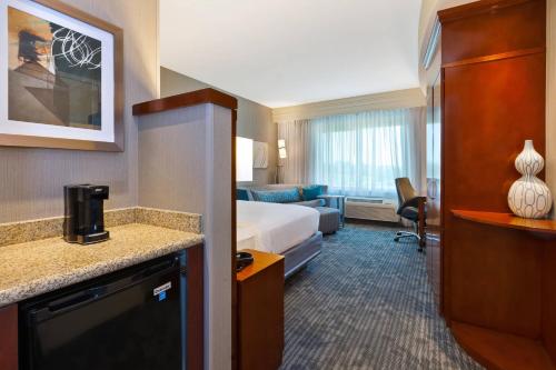 a hotel room with a bed and a couch at Courtyard Omaha La Vista in La Vista