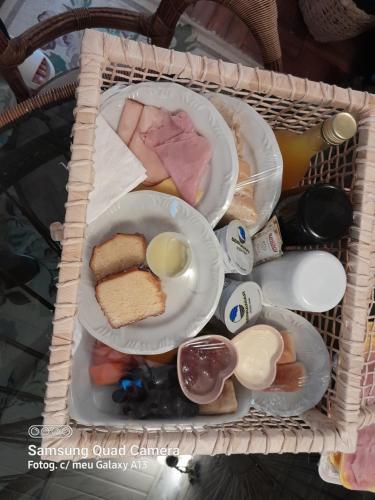 una cesta de comida con dos platos de comida en Chalé Rustic House 2 Com hidromassagem, en Campos do Jordão