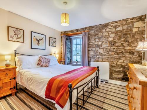 a bedroom with a bed and a stone wall at Cauldron Falls in West Burton
